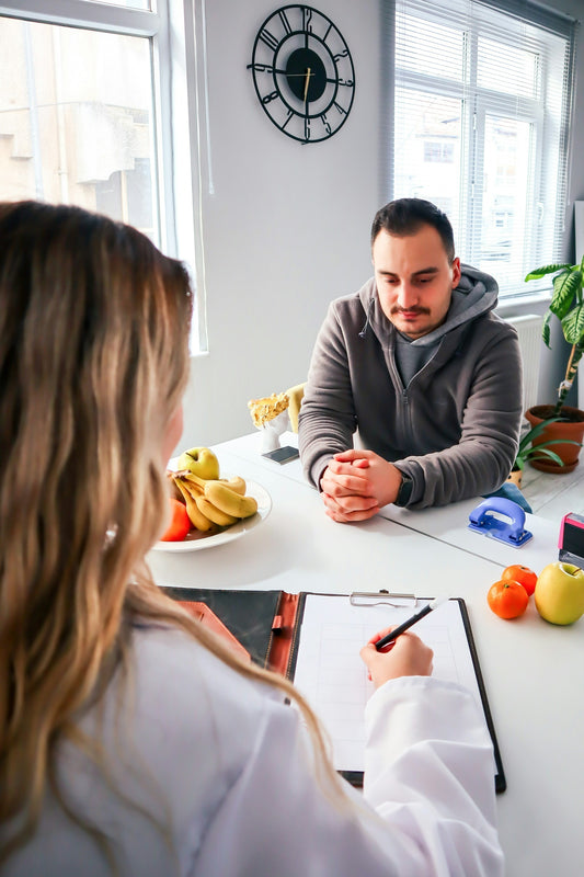 Naturopata in camice bianco a colloquio con un cliente — consulenza naturopatica online e in studio a Sarzana, Erboristeria Ippocrate